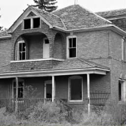 Before: neglected brick house with an overgrown yard