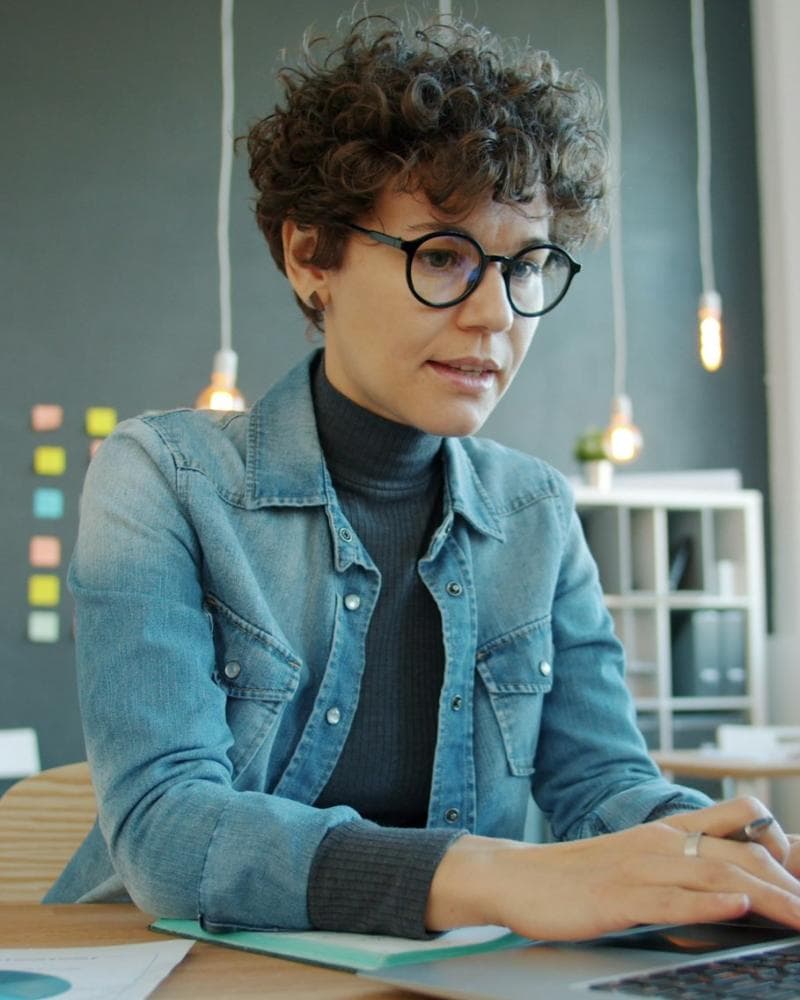 Office coordinator reviewing work orders on her laptop